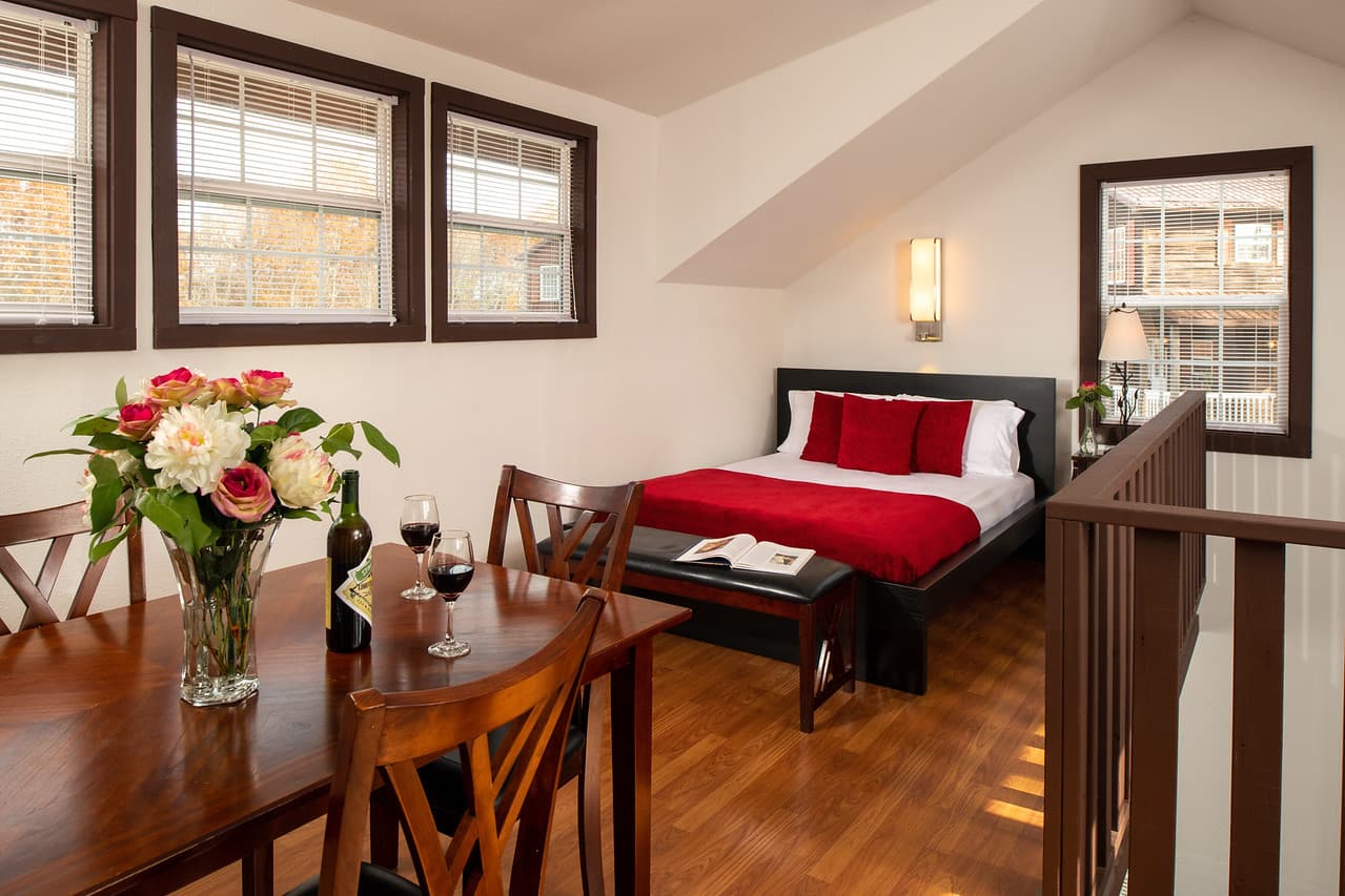 Upstairs view of dining table in foreground and bed in the background