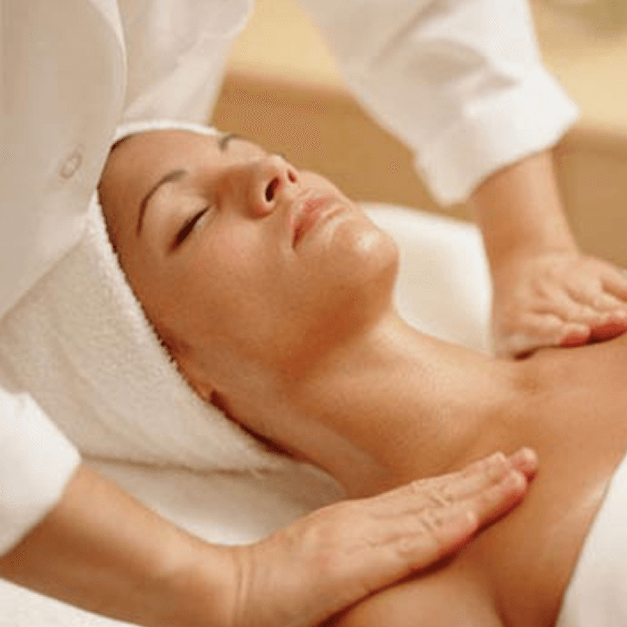 Woman laying on back with hair in towel esthetician standing over her