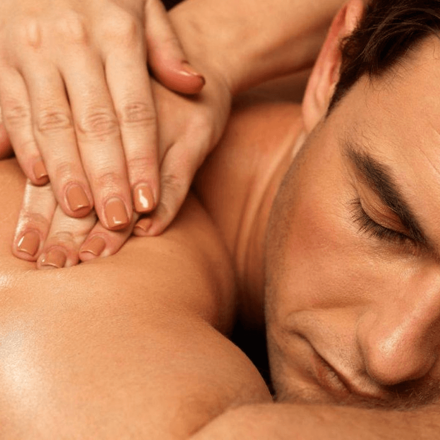Man laying on stomach with masseuse hands on his back